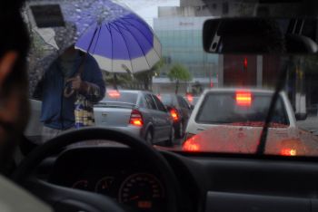 Carros parados no semáforo em dia chuvoso