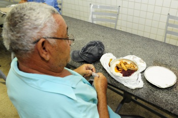 Senhor se preparando para almoçar no restaurante popular