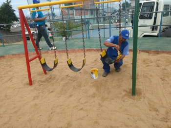 Operários recuperam e pintam equipamentos e brinquedos na praça do bairro Romão