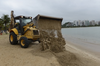 Trator utilizando pá mecânica para mover areia na praia da Curva da Jurema