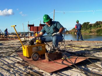 Trabalhador realizando obra próximo ao mangue