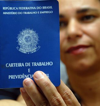 Mulher segura carteira de trabalho na mão