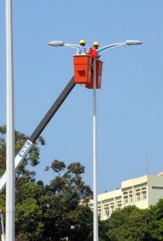 Funcionarios da Prefeitura instalam nova luminaria em poste de Camburi