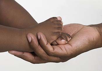 Mãos segurando pés de criança