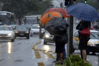 Pedestres na Avenida Nossa Senhora da Penha em dia de chuva