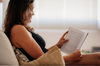 a documentarista tânia lendo livro em seu sofá