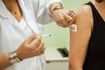 Mulher recebe vacina contra gripe no dia da campanha nacional
