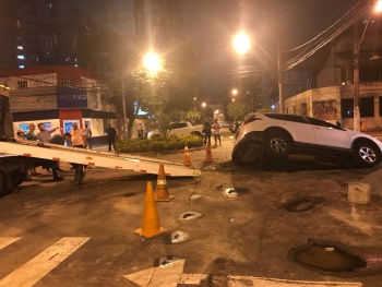carro cai dentro de buraco após asfalto ceder
