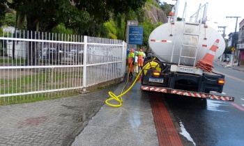 Garis lavam calçada contra coronavírus com caminhão pipa