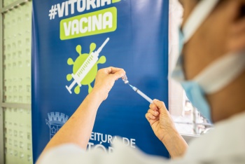 Enfermeiro abastecendo seringa com vacina contra Coronavírus