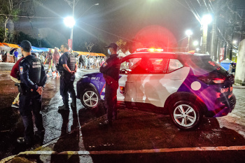 Agentes da Guarda Civil Municipal Comunitário ao lado da viatura.