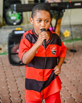 Kaique de Oliveira, 7 anos na apresentação do coral Serenata de Favela no SCFV de Nova Palestina