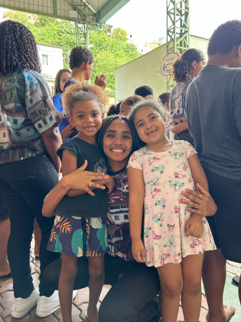 Letícia Barreto, corista do Serenata de Favela abraçada a crianças do SCFV Nova Palestina